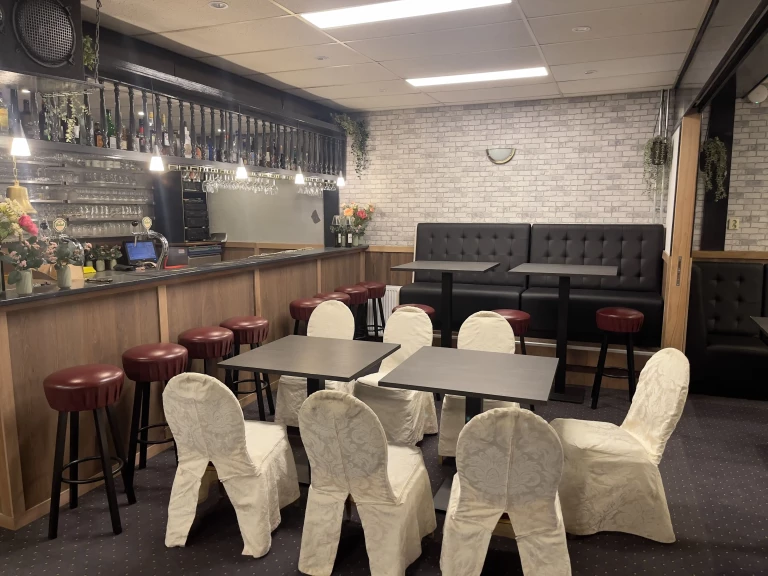 Gedeckte Tische und die Bar im Partykeller von ’t Bockje in Bathmen