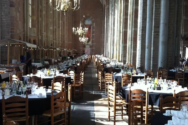 Catering opgesteld in een kerk, met schalen en kannen op een buffettafel