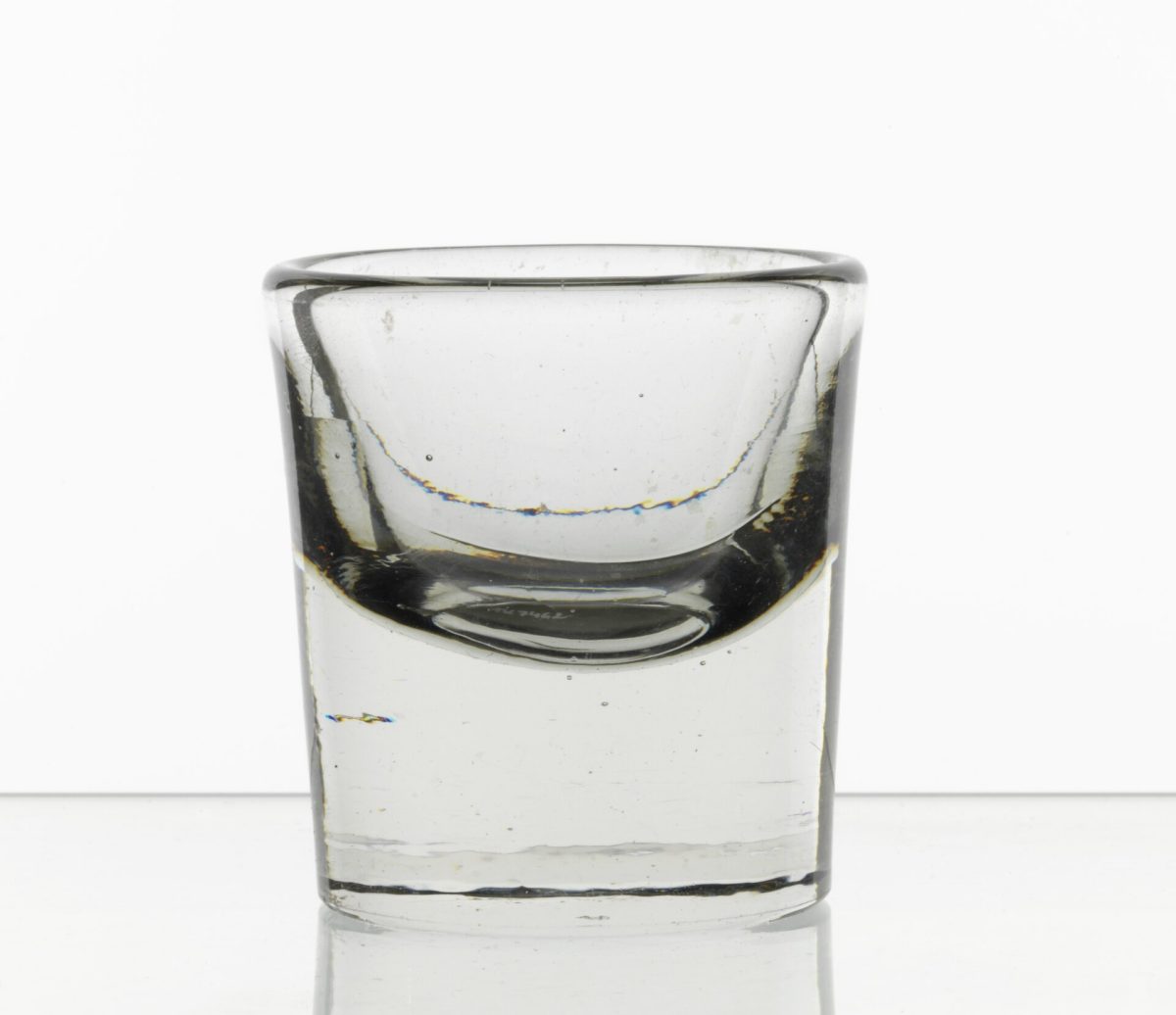 Een antiek jeneverglas met een dikke bodem