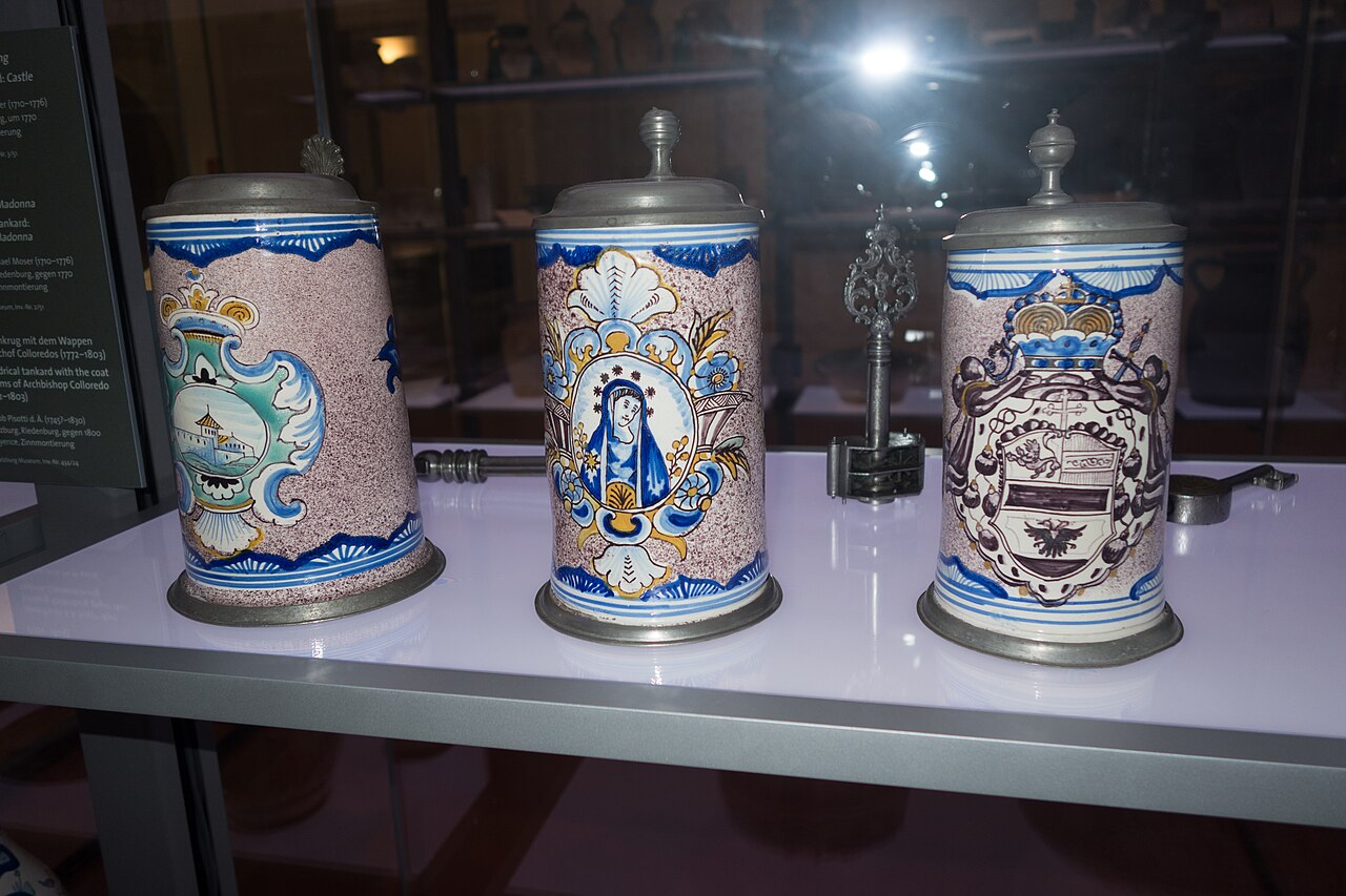 Antieke aardewerken bierpullen met tinnen deksel in een vitrine