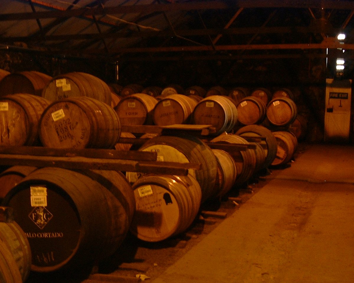 Rijen eikenhouten vaten op hun kant in een donker pakhuis van Bruichladdich op Islay