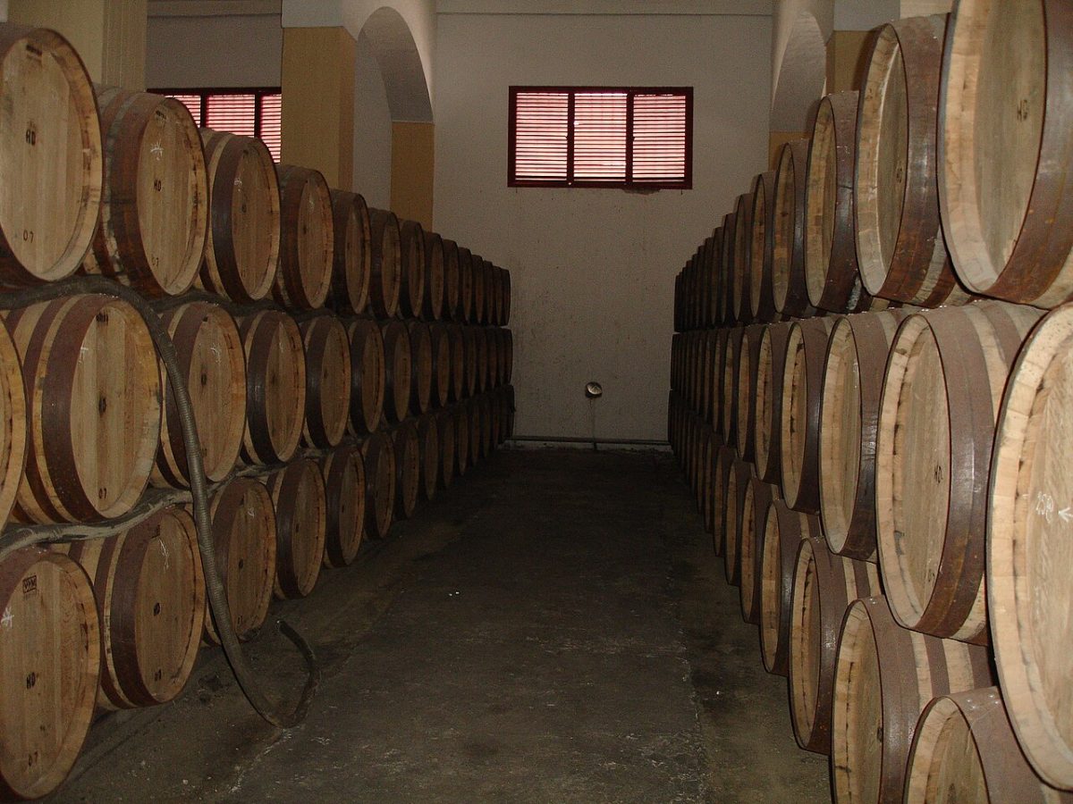 Rijen gestapelde eikenhouten sherryvaten in een bodega in Jerez
