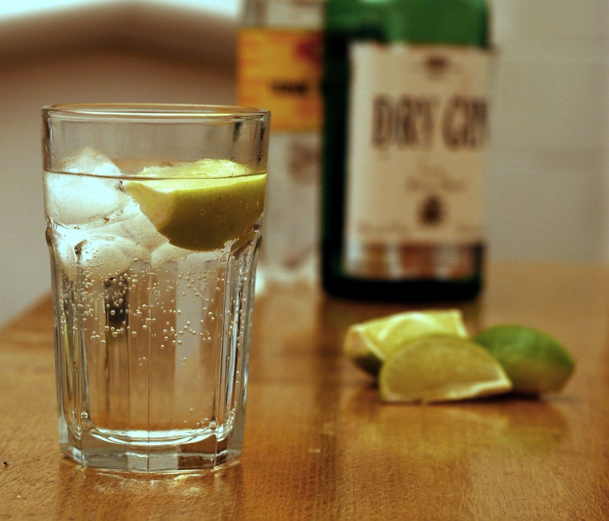 Een gin-tonic met limoen en ijs in een longdrinkglas