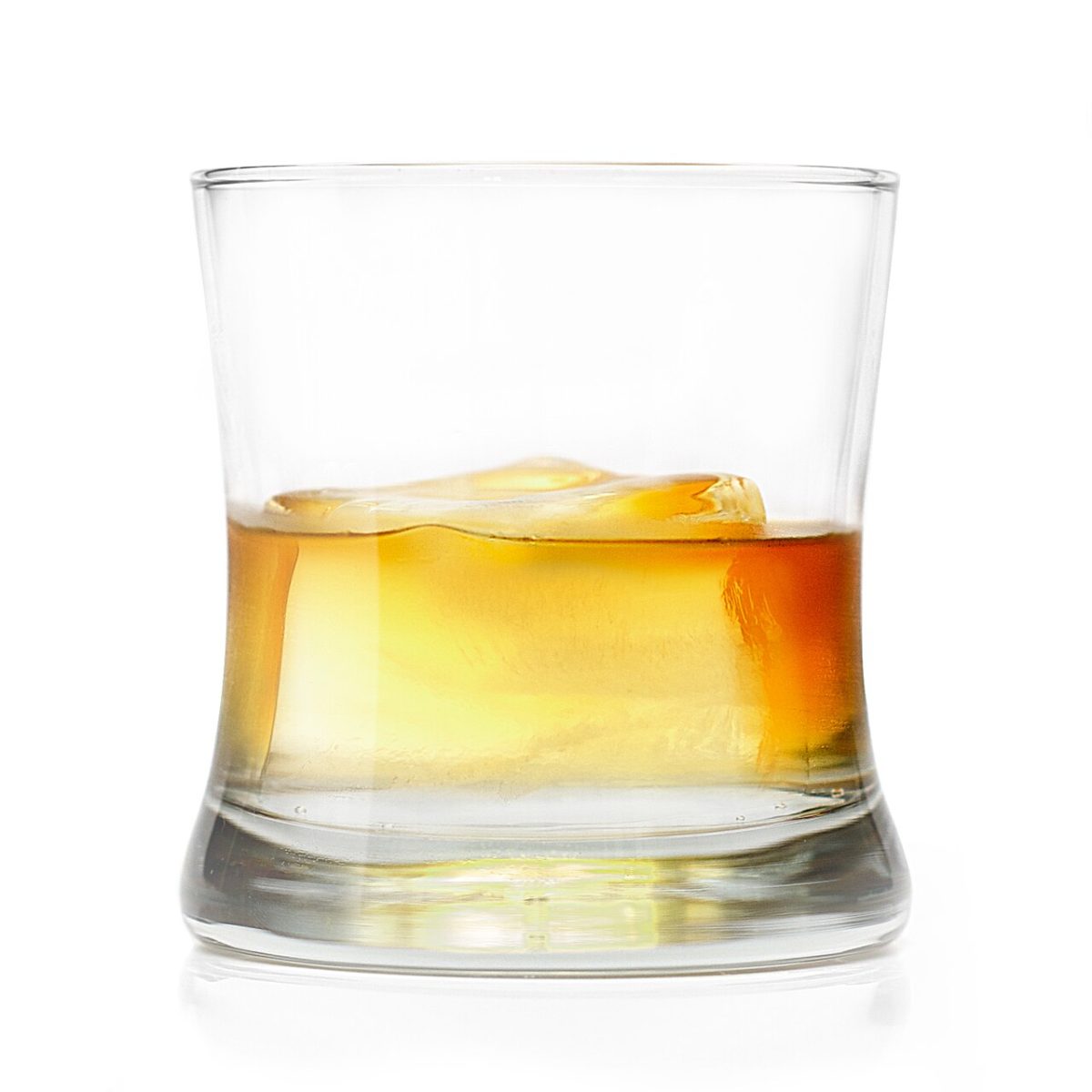 Een tumbler met een bruine gedistilleerde drank en ijsblokjes
