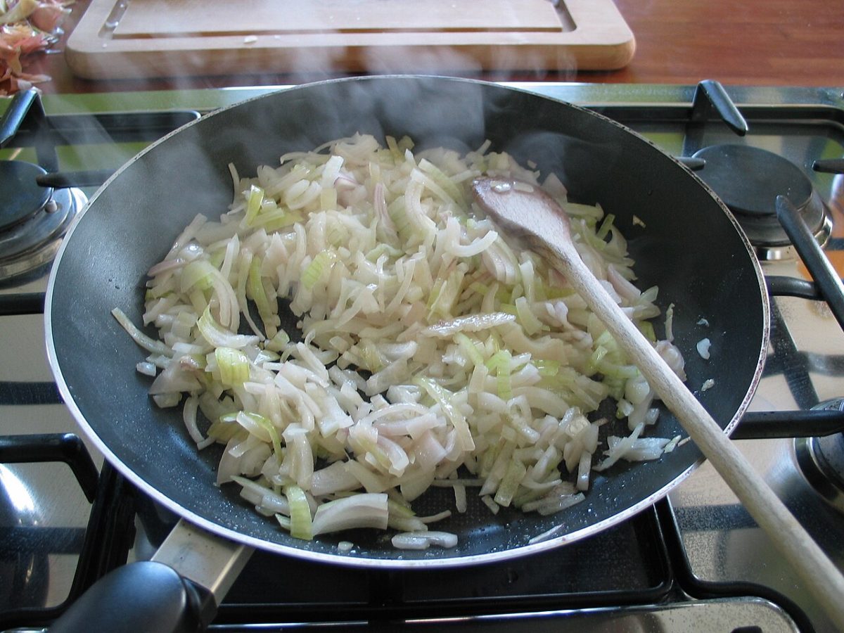 Uien die langzaam in een pan worden gefruit
