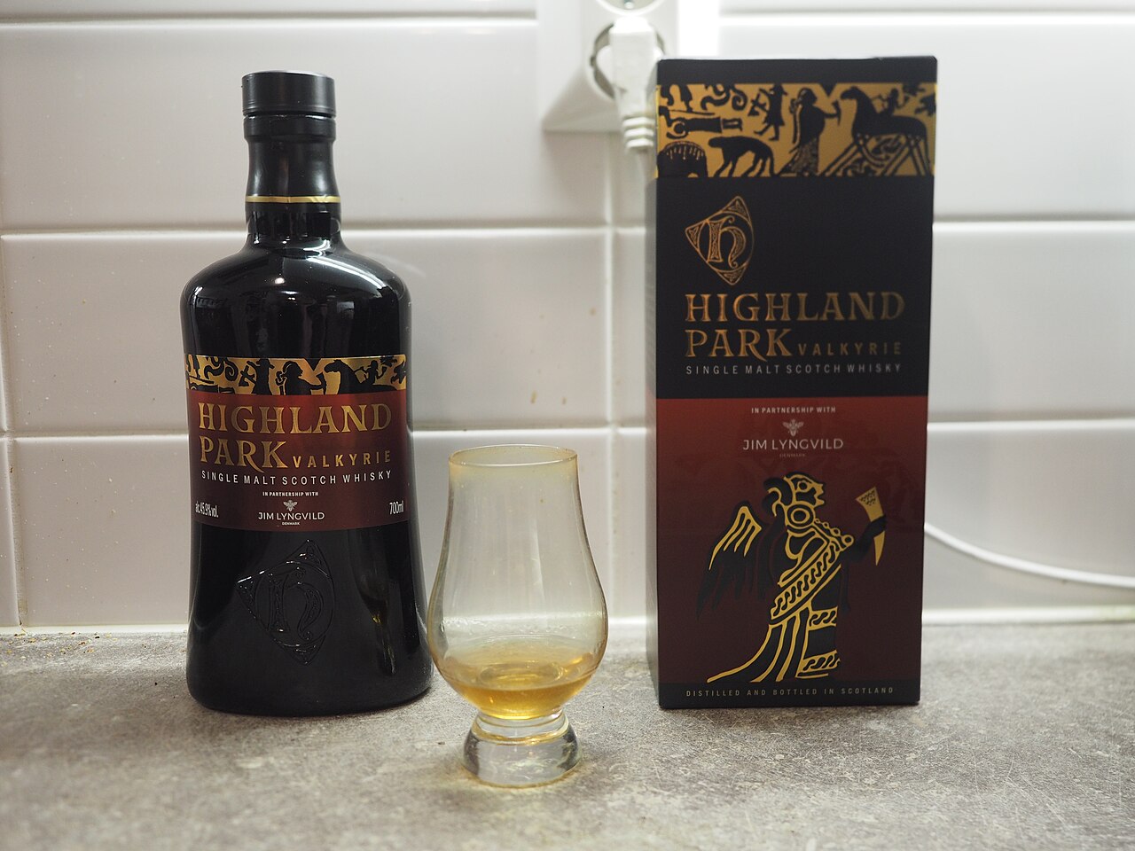Een fles whisky met een geschonken glas ernaast