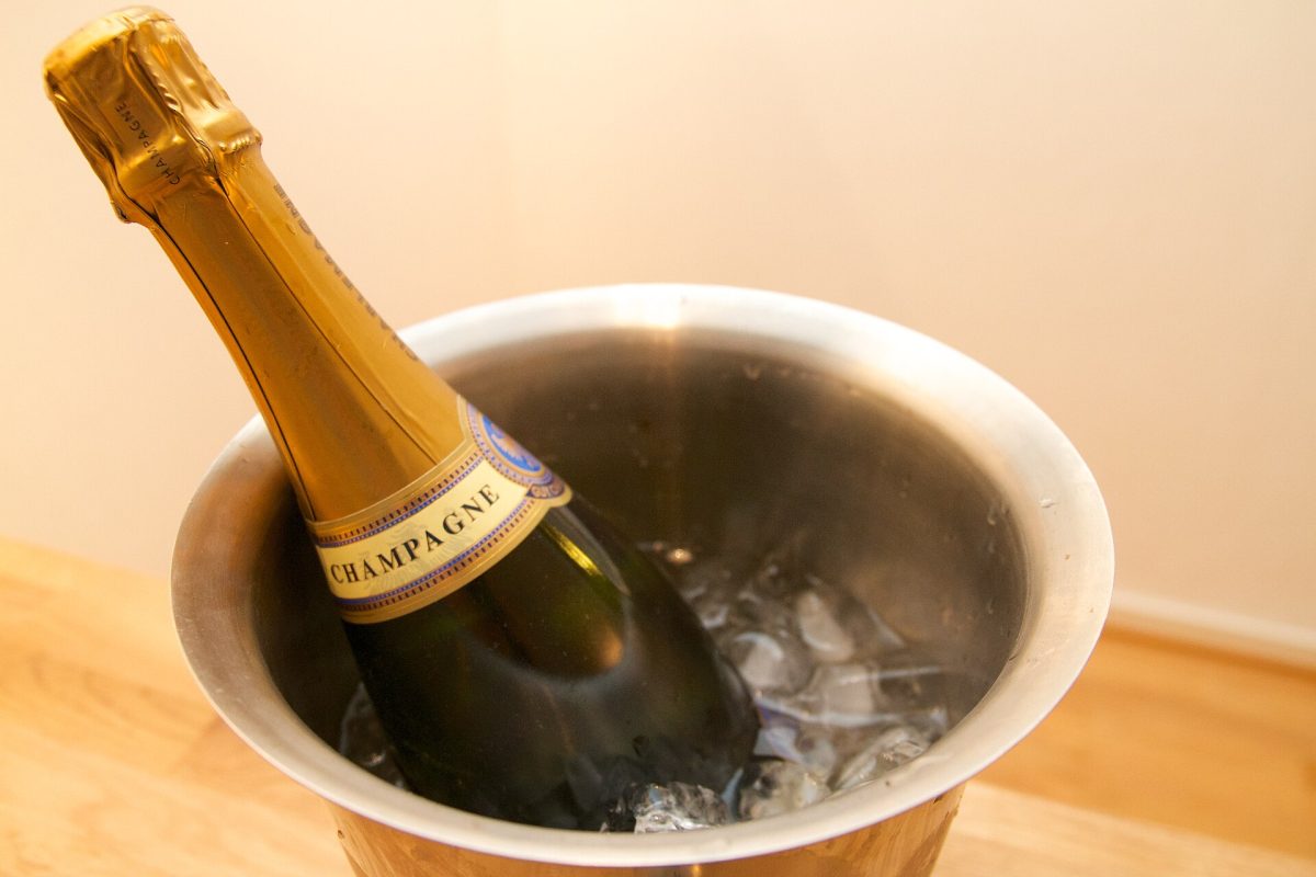 Een fles rechtop in een metalen koeler met ijs