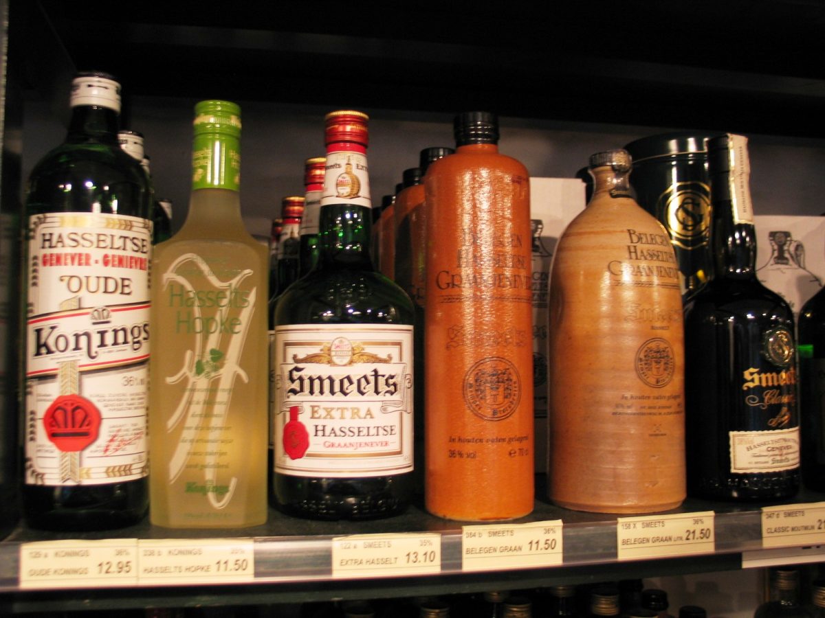 Flessen en stenen kruiken Hasseltse jenever op een schap