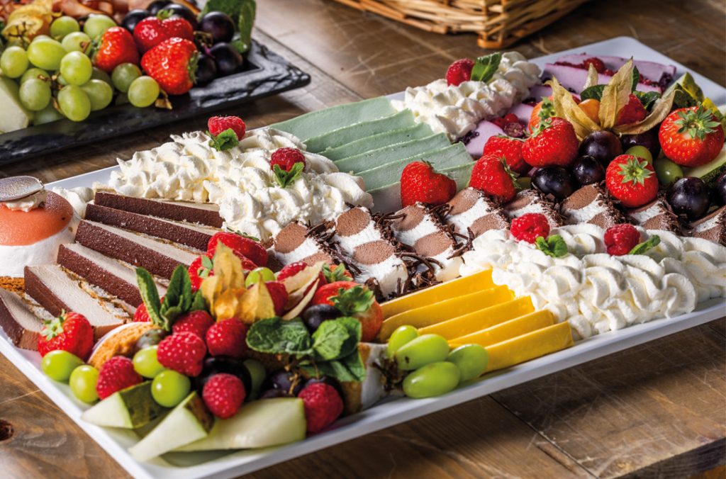 Dessertplateau met fruit, taart en bavarois