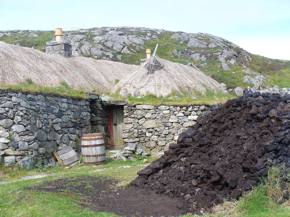 Une pile de tourbe séchée à côté d’une maison à Gearrannan, sur Lewis