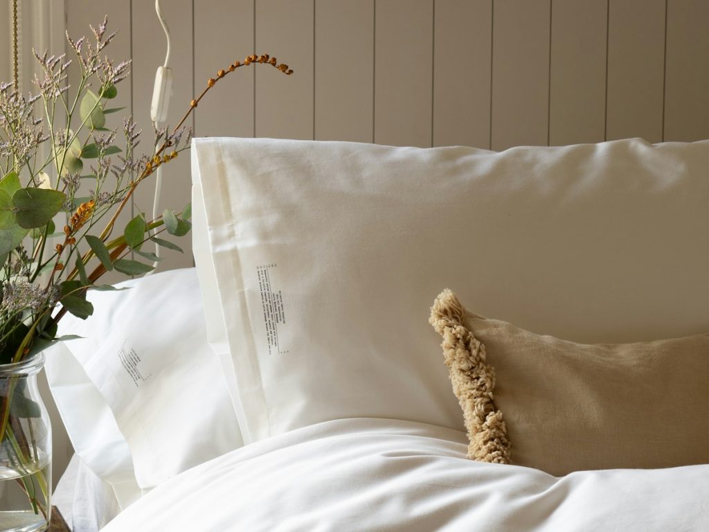 A made bed with a white duvet and white pillows