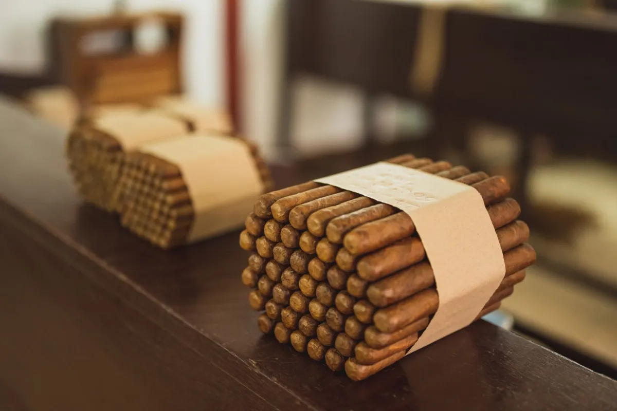 Bundels sigaren, samengebonden met een papieren band, op een houten toonbank