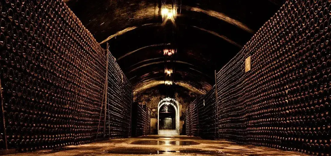 De lange kelderganggang van Bollinger met flessen op latten
