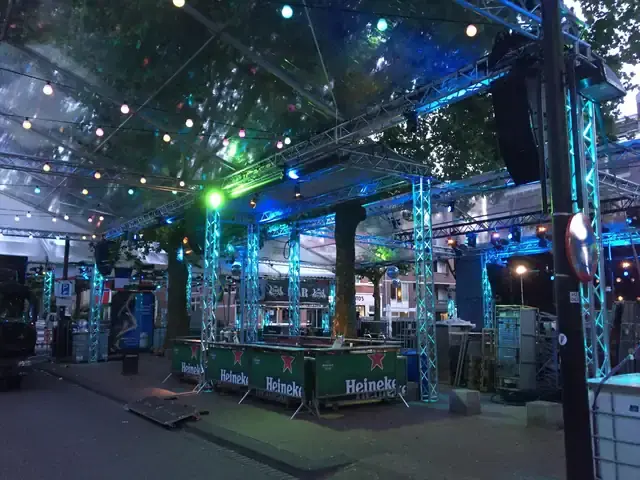 Bars onder een trussconstructie met blauwe en groene verlichting
