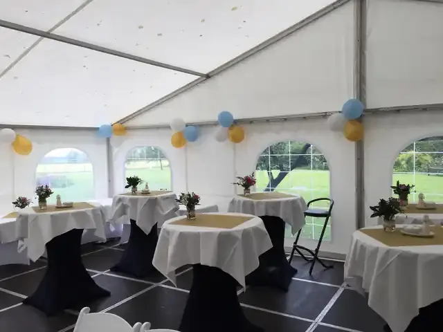 Partytent met statafels, gedekte tafels en ballonnen