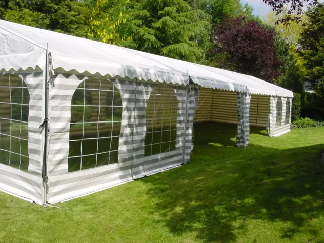 Witte partytent van 5 meter breed met ramen in de zijkantzeilen op een gazon