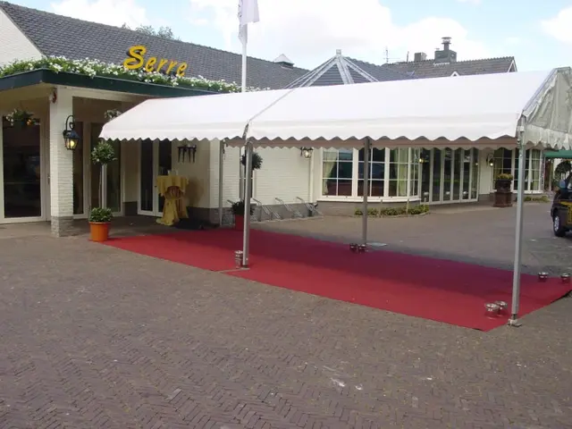 Smalle witte partytent als overdekte entree met rode loper
