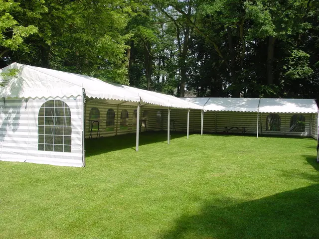 Lange witte partytent met ramen op een groot gazon